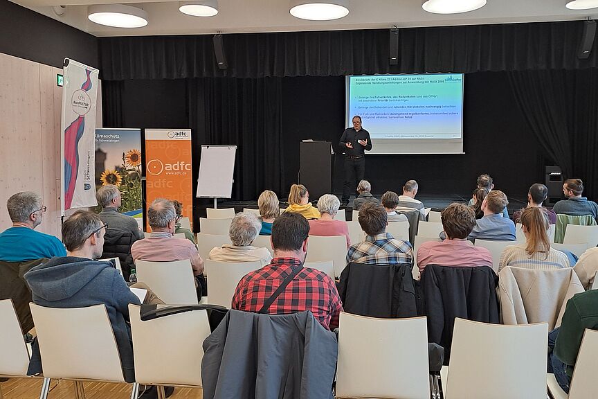 Fachveranstaltung des ADFC Rhein-Neckar Ein Saal mit Menschen, die dem Vortrag einer Person zu hören.